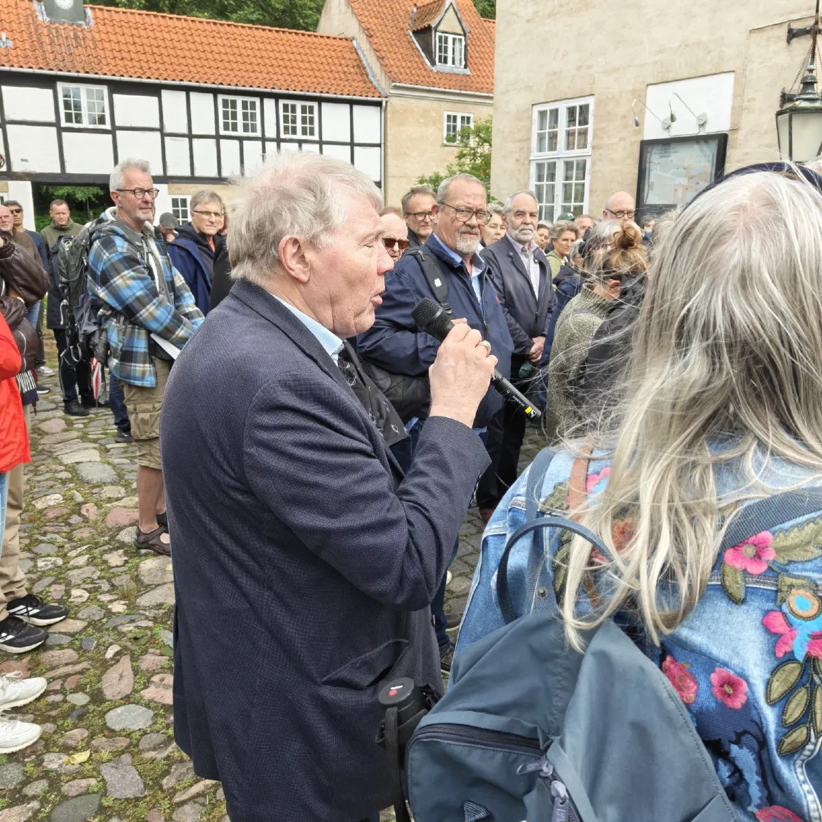 Borger stiller spørgsmål med mikrofon i Haraldsgaves gårdsplads