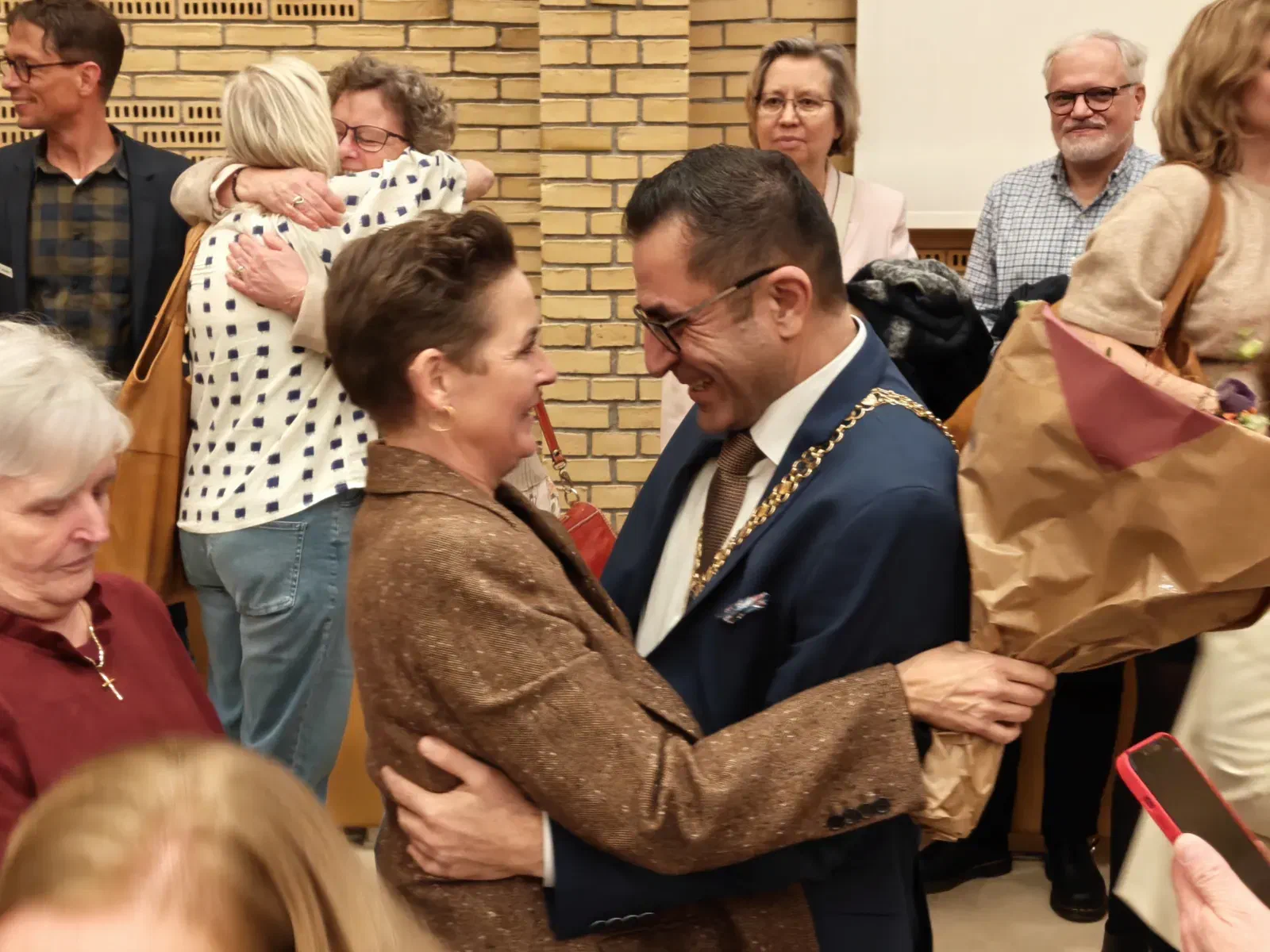 Serdal Benli omfavner en gratulant i byrådssalen