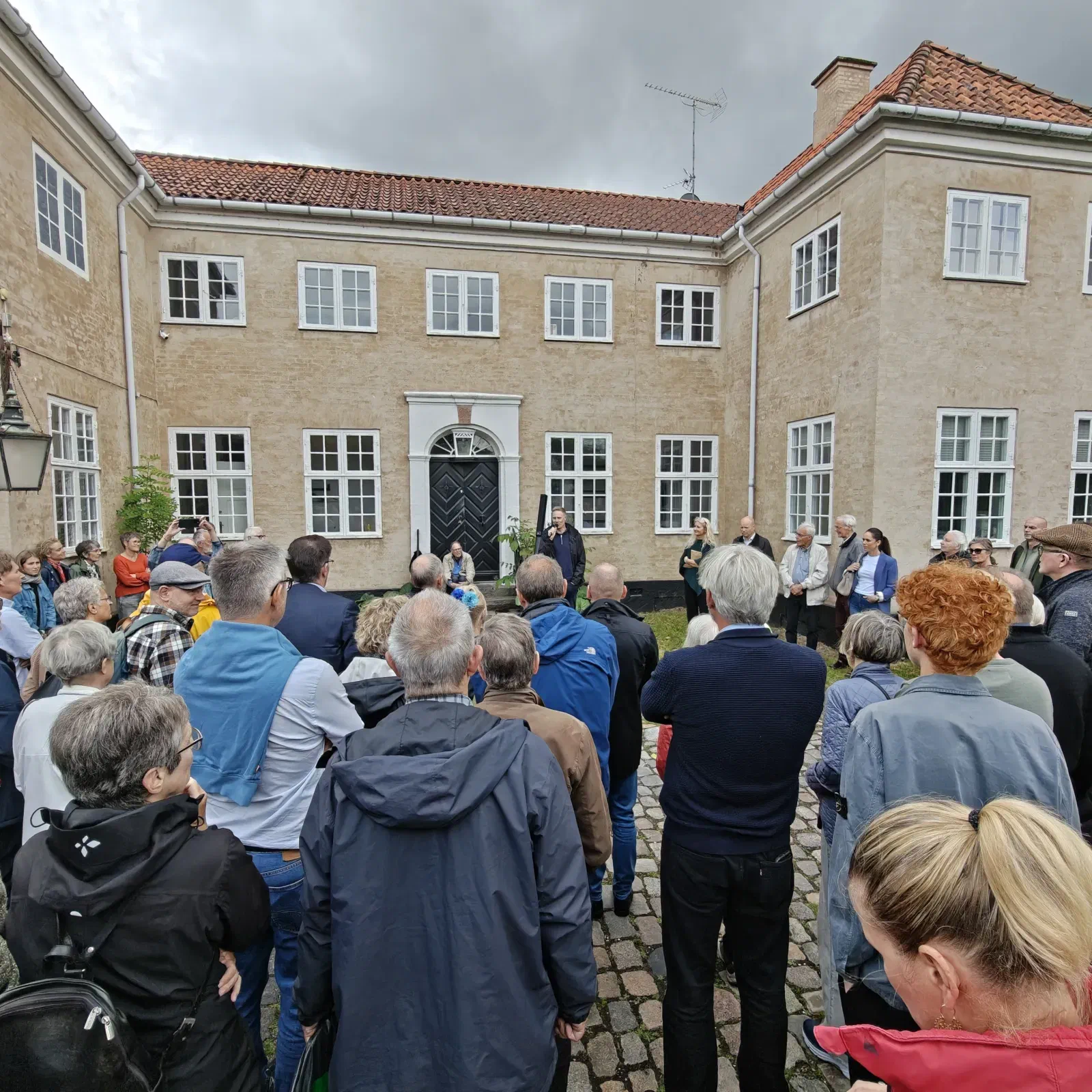 Stor forsamling af borgere i gårdspladsen foran Haraldsgaves hovedbygning