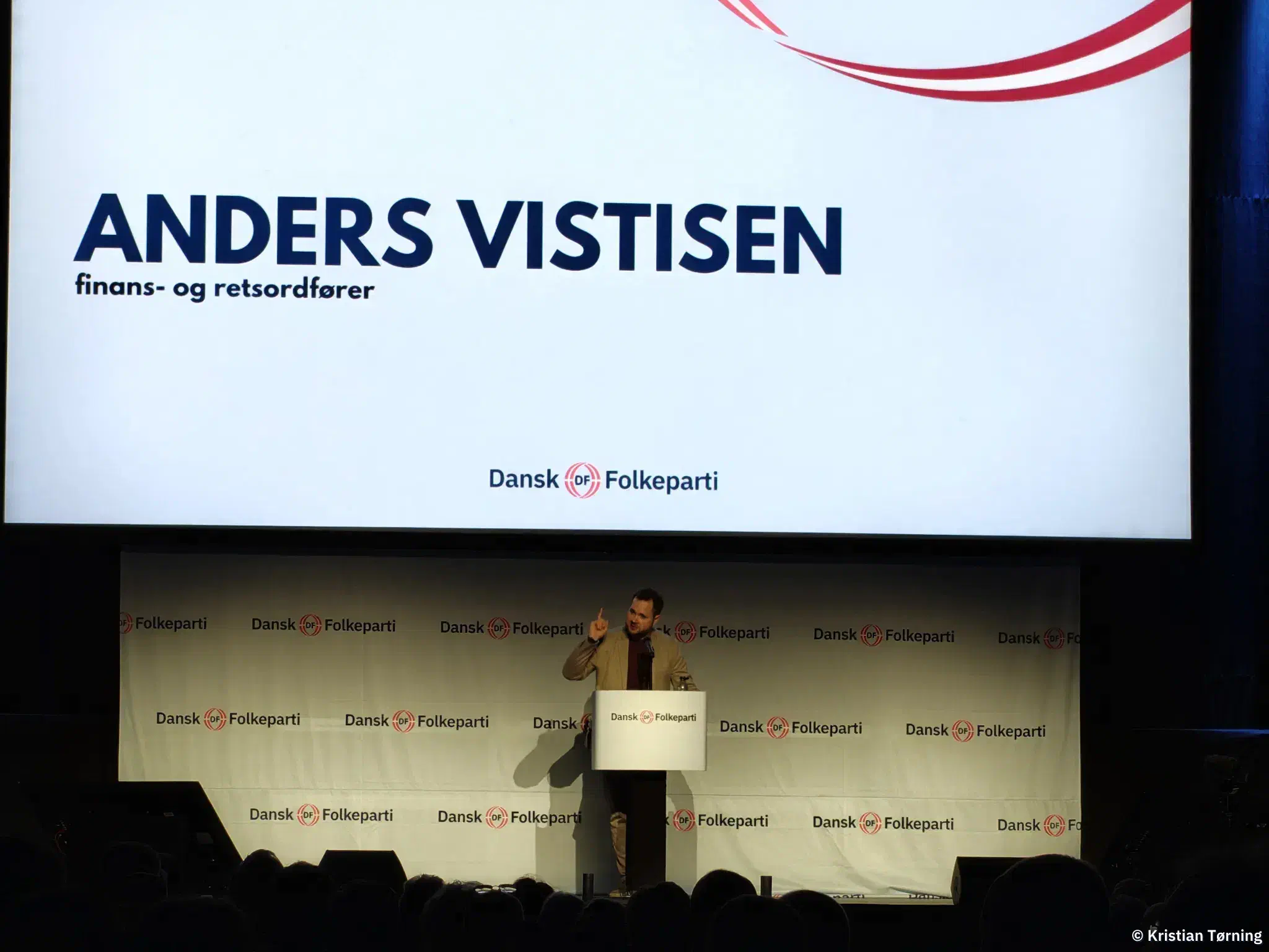 Anders Vistisen på talerstolen under en skærm med hans navn