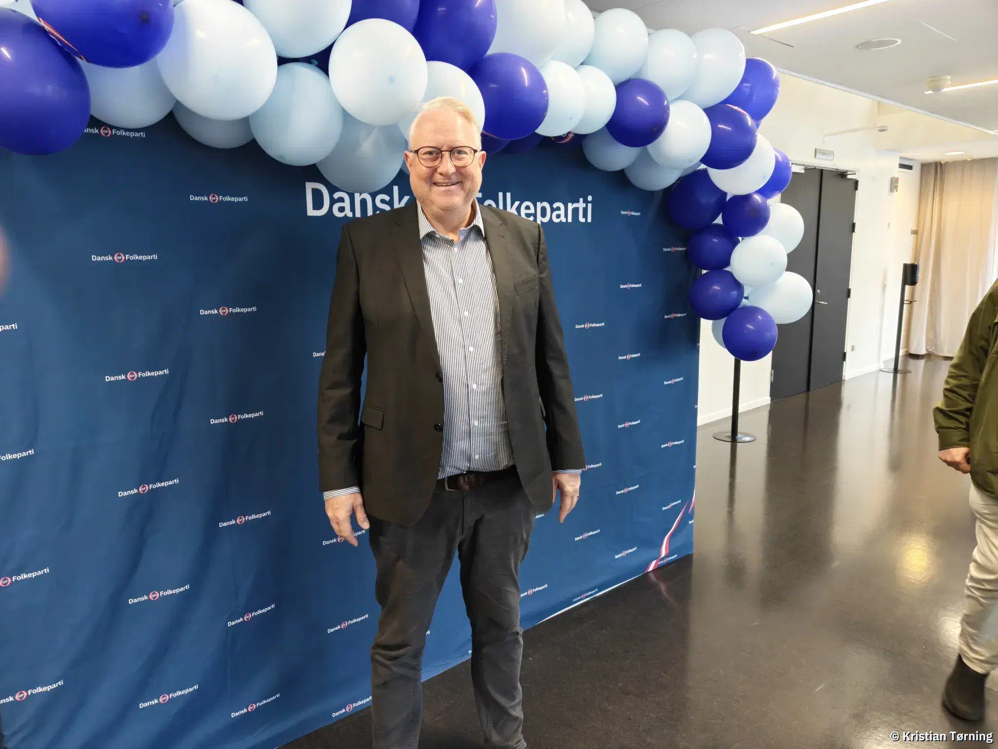 Kristian Tørning foran et Dansk Folkeparti-banner med blå og hvide balloner