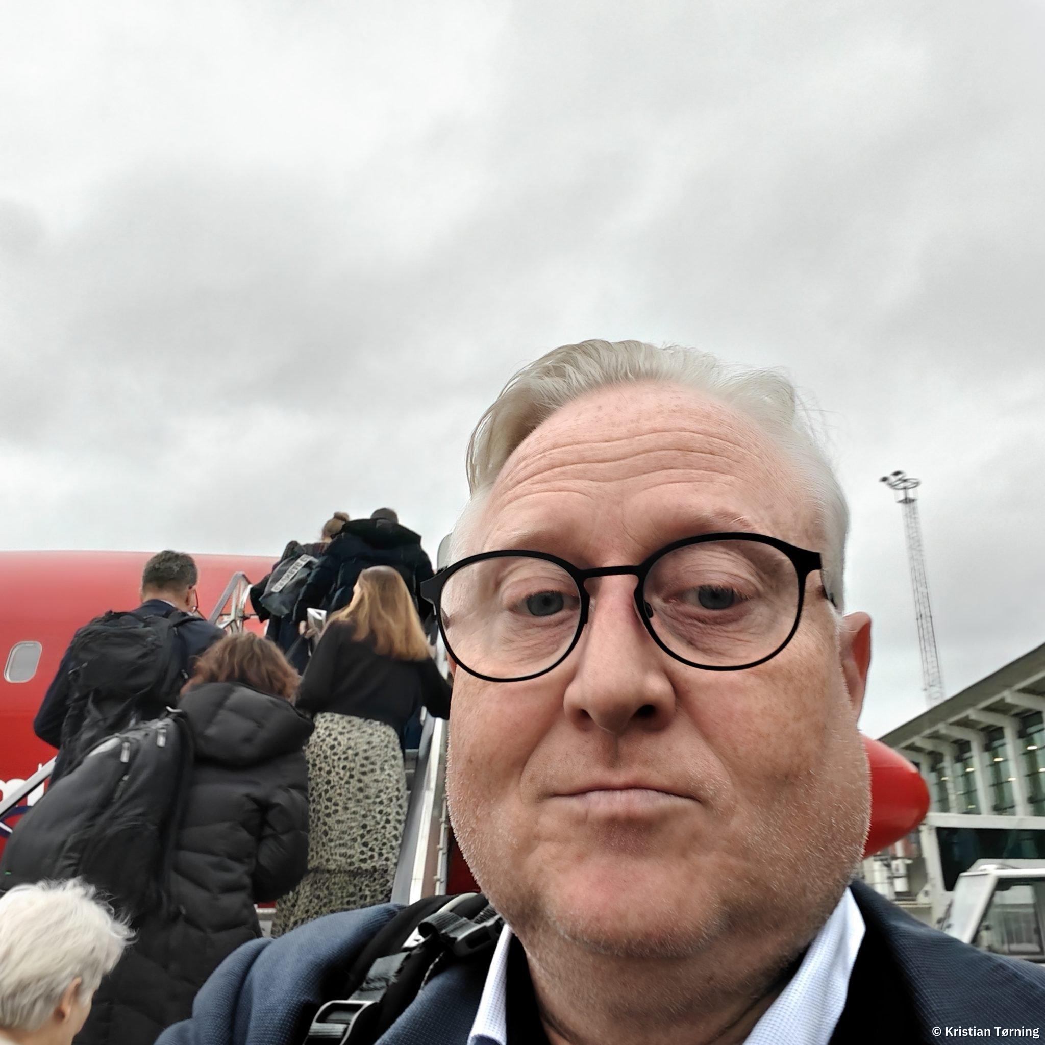Kristian Tørning i selfie ved flytrappen under ombordstigning
