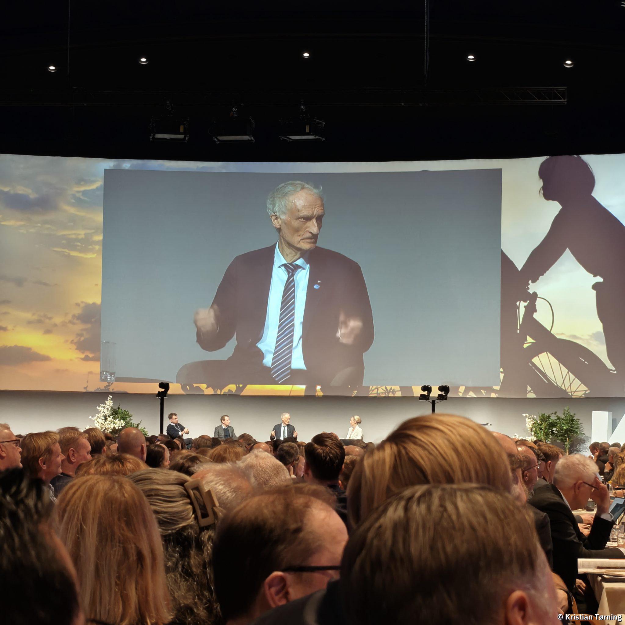 Paneldeltager vist på storskærm over scenen i kongressalen