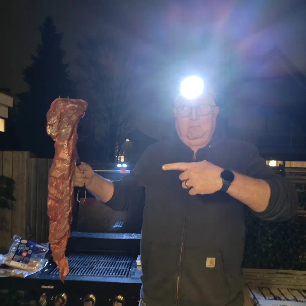 Kristian Tørning med pandelampe griller en stor bøf en vinteraften