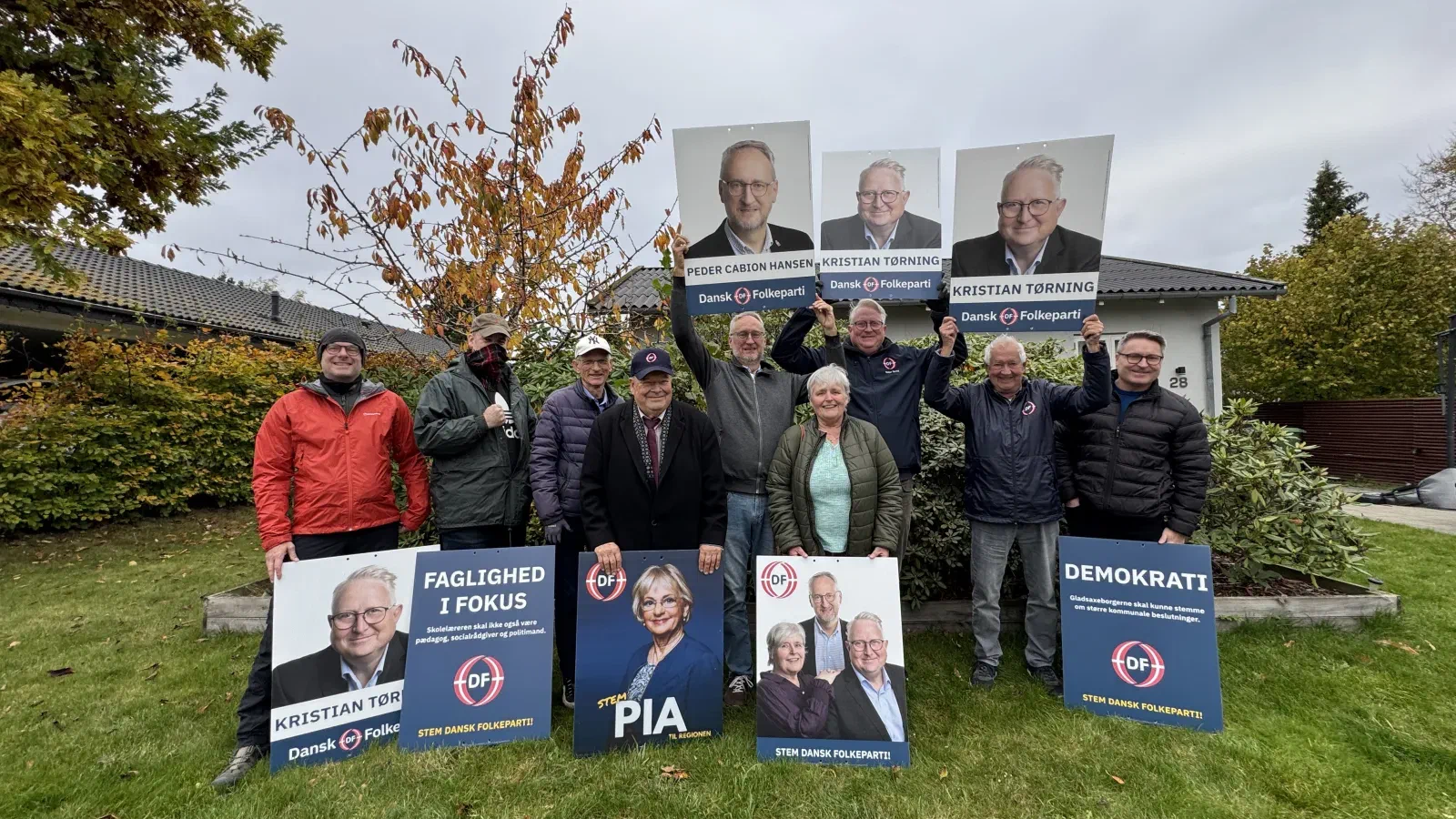 Valgkampsholdet fra Dansk Folkeparti i Gladsaxe med plakater i en forhave